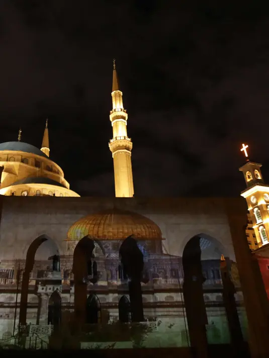 Masjid Al-Amin dan Katedral Christian Maronite saat diterangi cahaya bergambar masjid al-Aqsa dan gereja Makam Suci di Kota Tua Yerusalem di Beirut, Lebanon, (7/12). (AFP Photo/Anwar Amro)