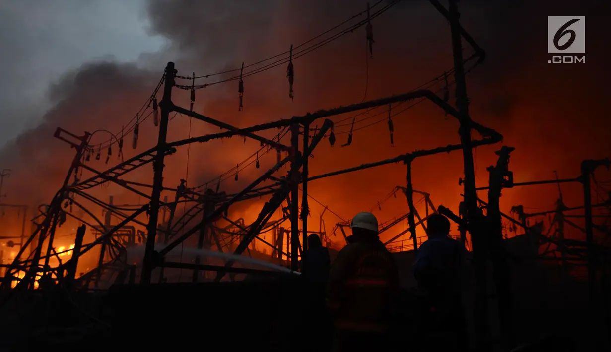 Petugas damkar berusaha menjinakan api yang membakar kapal nelayan di Pelabuhan Muara Baru, Penjaringan, Jakarta Utara, Sabtu (23/2). Sebanyak 18 kapal nelayan terbakar yang belum diketahui penyebabnya. (merdeka.com/Imam Bukhori)