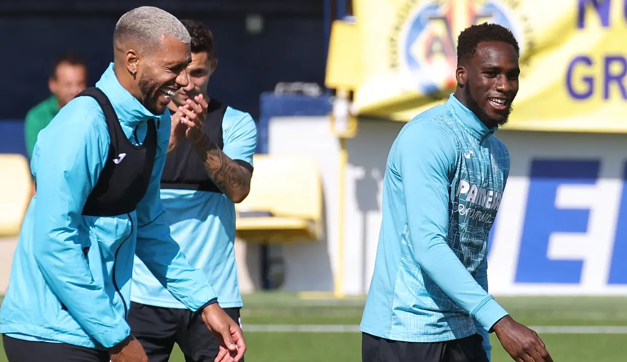 Gelandang Villarreal Etienne Capoue bercanda dengan Boulaye Dia selama sesi latihan di Ciudad Deportiva Villarreal di Vila-Real pada Selasa (28/9/2021). Villarreal akan bertandang ke markas Manchester United (MU) pada laga Grup F Liga Champions 2021/2022, Kamis dini hari WIB. (JOSE JORDAN/AFP)