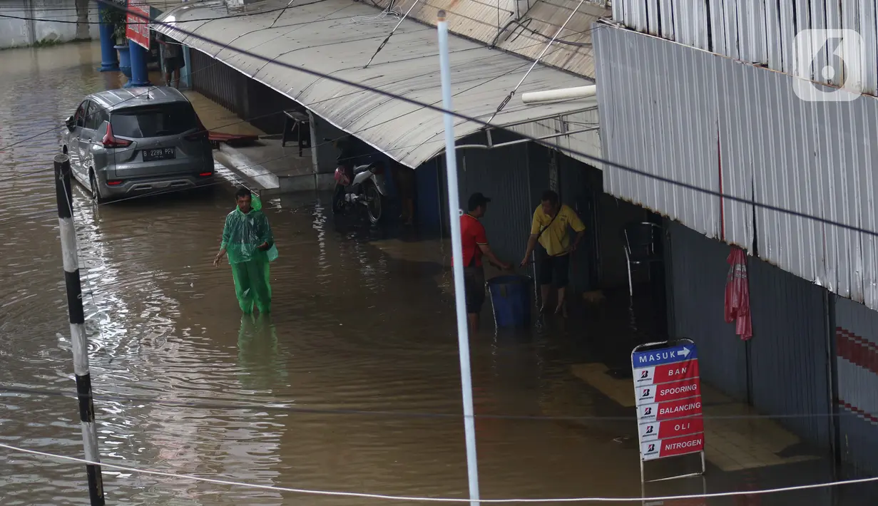 Aktivitas warga saat banjir merendam sejumlah pertokoan di sekitar Jalan Gunung Sahari, Jakarta, Selasa (25/2/2020). Hujan yang mengguyur Jakarta sejak Senin (24/2/2020) malam, membuat sejumlah kali meluap dan menyebabkan banjir. (Liputan6.com/Helmi Fithriansyah)