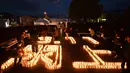 Pengunjung melihat lilin yang membentuk angka 3.11 dan nama kota Yuriage saat upacara peringatan bencana gempa tsunami yang terjadi pada tahun 2011 di Natori, Prefektur Miyagi, Jepang (11/3). (AFP/Kazuhiro Nogi)