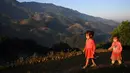 Anak-anak etnis Hmong berjalan di sepanjang sawah terasering di provinsi Yen Bai, Vietnam pada 28 November 2021. Sawah sangat indah pada bulan September dan Oktober, ketika tanaman berubah menjadi kuning mengkilap. (Nhac NGUYEN / AFP)