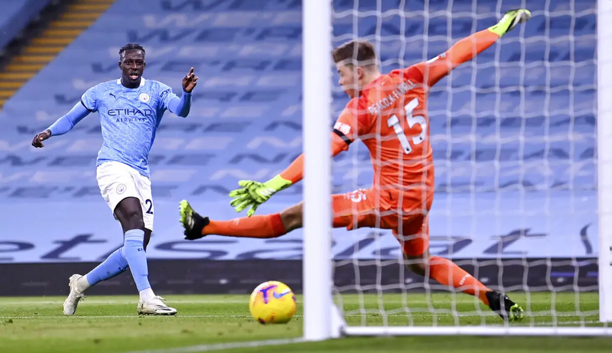 Pemain Manchester City Benjamin Mendy (kiri) mencetak gol ke gawang Burnley pada pertandingan Liga Premier Inggris di Etihad Stadium, Manchester, Inggris, Sabtu (28/11/2020). Manchester City melesat ke urutan delapan klasemen usai membantai Burnley 5-0. (Laurence Griffiths/Pool via AP)