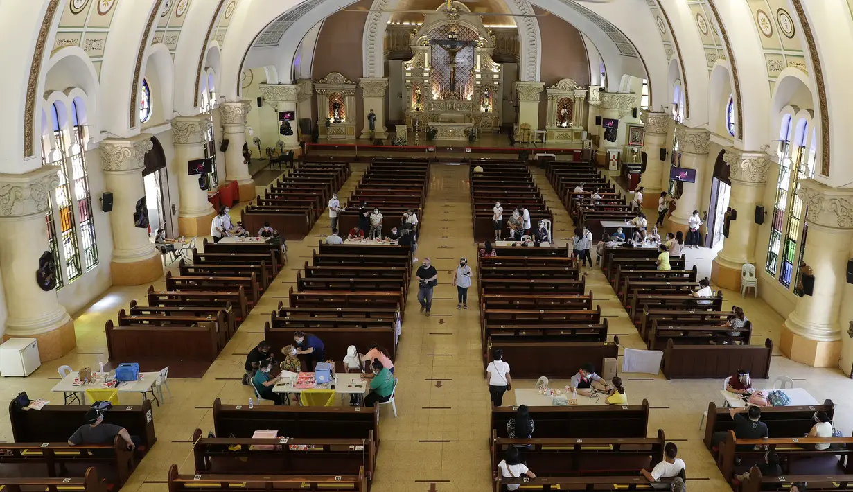 Petugas kesehatan menyuntik warga dengan vaksin COVID-19 produksi AstraZeneca di dalam gereja Paroki Hati Kudus Yesus di Quezon City, Filipina, Senin (17/5/2021). Sempat ditangguhkan, Filipina melanjutkan penggunaan vaksin AstraZeneca pada penduduk berumur di bawah 60 tahun. (AP Photo/Aaron Favila)