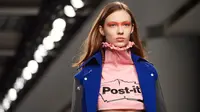 Model mengenakan crop top label Fyodor Golan edisi Fall/Winter 2017 dengan logo Post-it selama London Fashion Week di London, 17 Februari 2017. Label Inggris itu menunjukkan busana yang unik dan inspirasinya datang dari meja kerja. (NIKLAS HALLE'N/AFP)