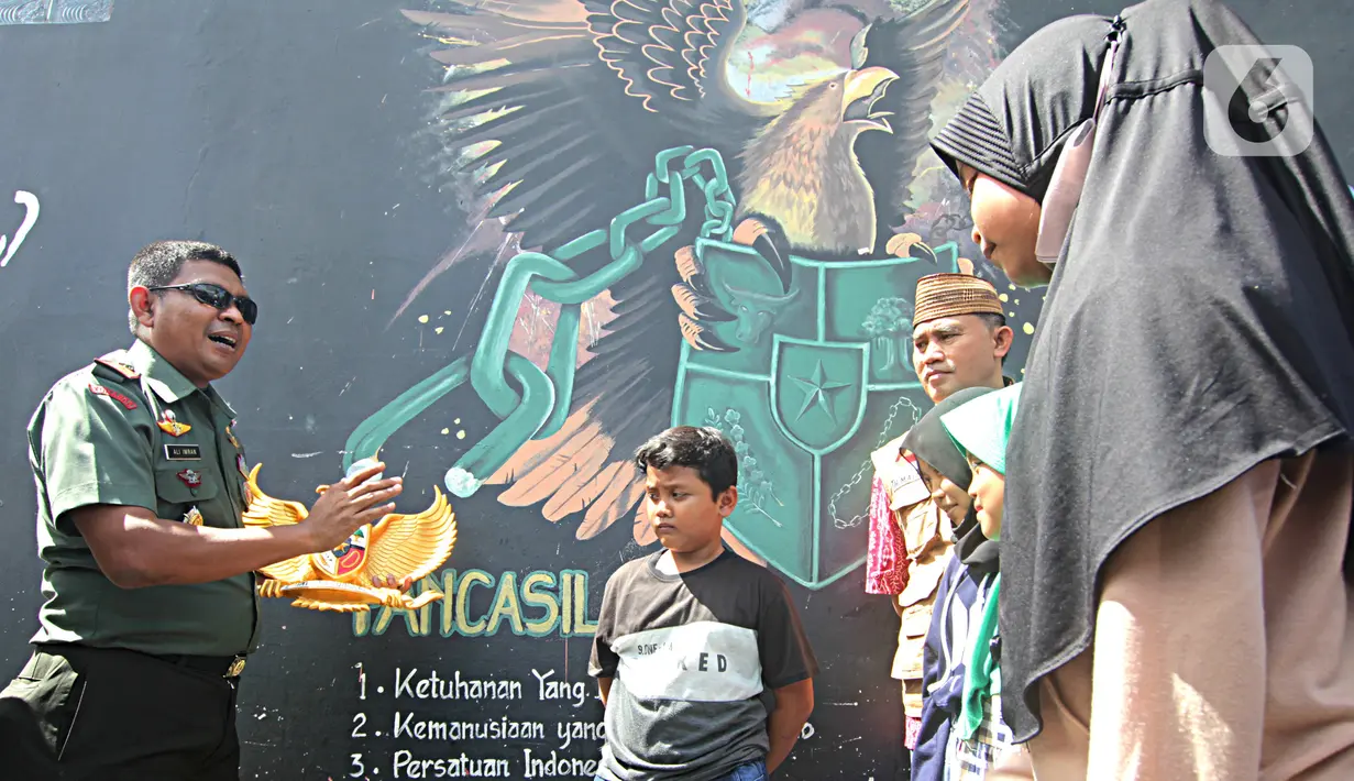 Dandim 0506/Tgr, Letkol Inf Ali Imran saat memberikan informasi tentang nilai-nilai Pancasila kepada sejumlah anak di Kampung Tematik Kampung Teras Pancasila, Karang Tengah, Tangerang, Banten, Rabu (1/6/2022).  (Liputan6.com/Angga Yuniar)
