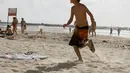 Seorang bocah Israel berusaha berlari menyelamatkan diri dari pantai yang diduga akan menjadi sasaran roket Hamas, Israel, Senin (14/07/2014) (AFP PHOTO/GALI TIBBON)