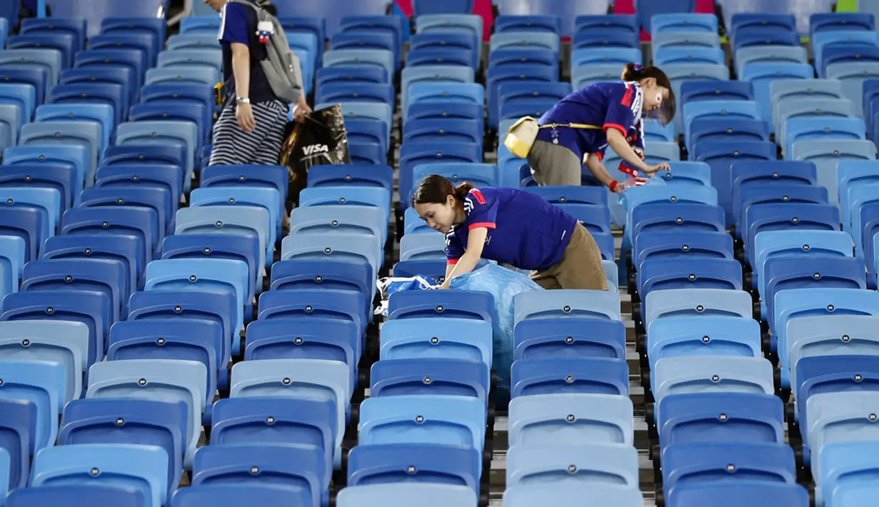 Usai menyaksikan laga Jepang melawan Yunani di Stadion Dunas, Natal, Brasil, (20/6/2014), suporter Samurai Biru melakukan aksi simpatik dengan membersihkan sisa-sisa makanan dan minuman. (REUTERS/Toru Hanai)