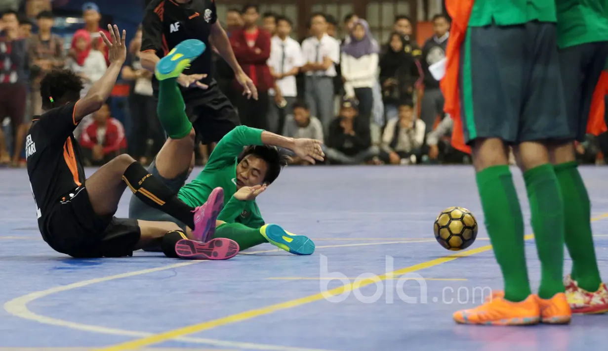 Pemain Timnas Futsal Indonesia, Ardy Dwi terjatuh saat berebut bola dengan pemain Blacksteel Manokwari pada laga uji coba jelang AFF Championship 2017 Thailand di Tifosi Sport Center, Selasa (16/1/2016). Timnas menang 8-6. (Bola.com/Nicklas Hanoatubun)