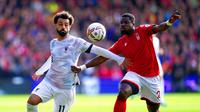 Pemain Liverpool Mohamed Salah (kiri) berebut bola dengan pemain Nottingham Forest Serge Aurier pada pertandingan sepak bola Liga Inggris di City Ground, Nottingham, Inggris, 22 Oktober 2022. Liverpool dikalahkan dengan skor 0-1. (Joe Giddens/PA via AP)