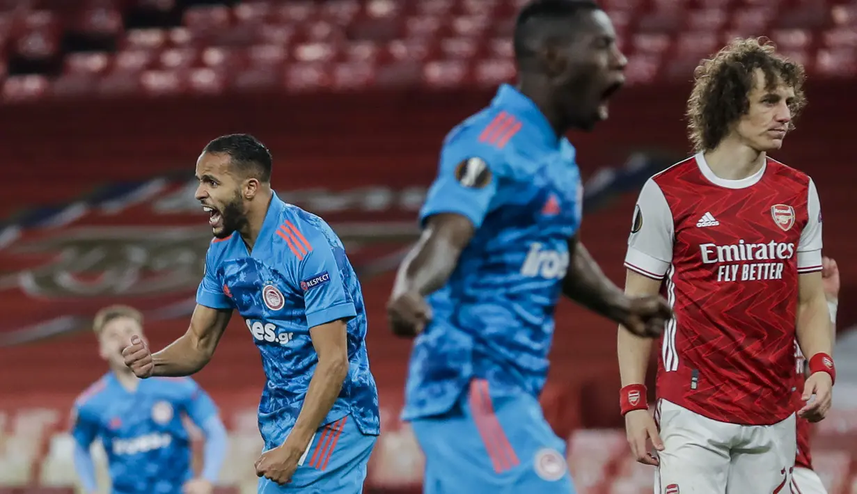 Striker Olympiakos, Youssef El-Arabi (kiri) melakukan selebrasi usai mencetak gol ke gawang Arsenal dalam laga leg kedua babak 16 besar Liga Europa 2020/2021 di Emirates Stadium, London, Kamis (18/3/2021). Olympiakos menang 1-0 atas Arsenal. (AP/Matt Dunham)