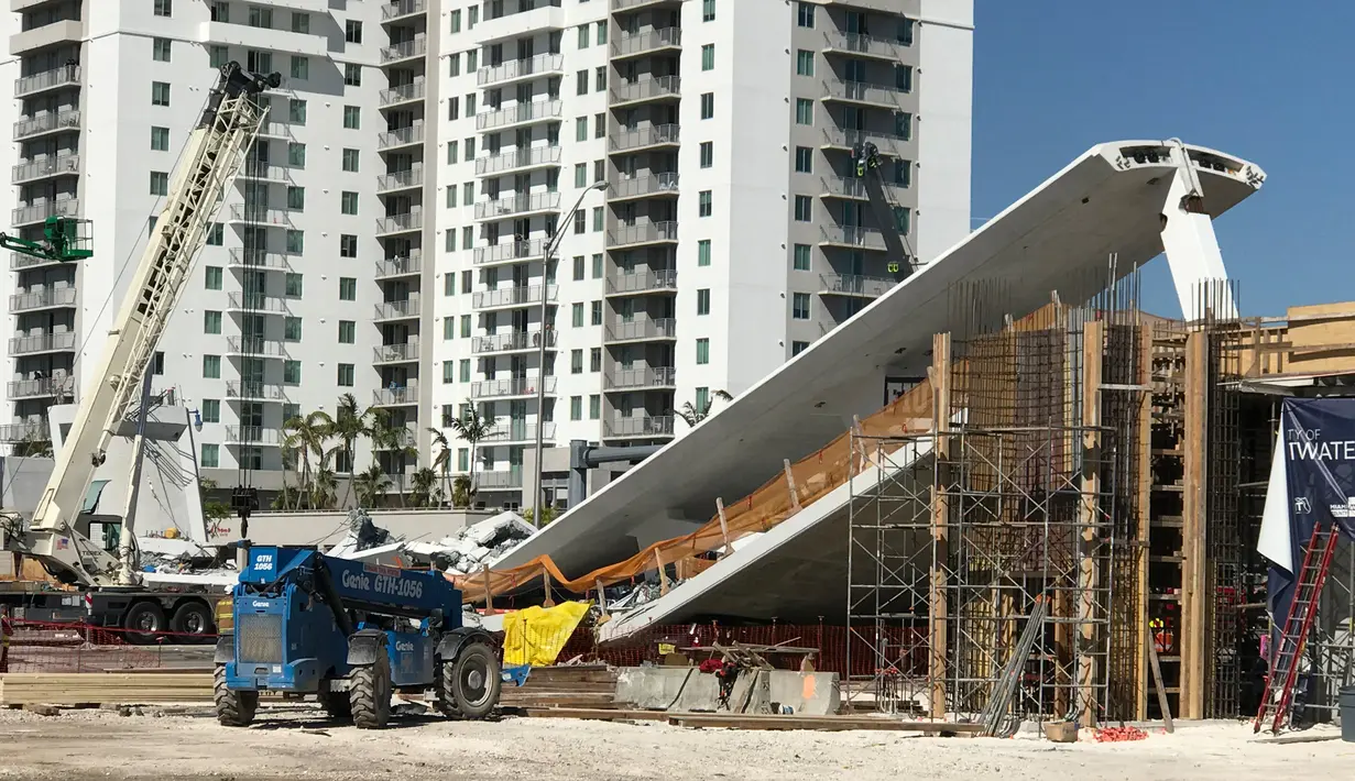 Alat berat dikerahkan untuk mengevakuasi korban runtuhnya jembatan pejalan kaki di Miami, Florida (15/3). Jembatan penyeberangan yang baru dibangun itu terletak di sebuah kampus di Miami. (AFP Photo/AFP TV/Antoni Belchi)