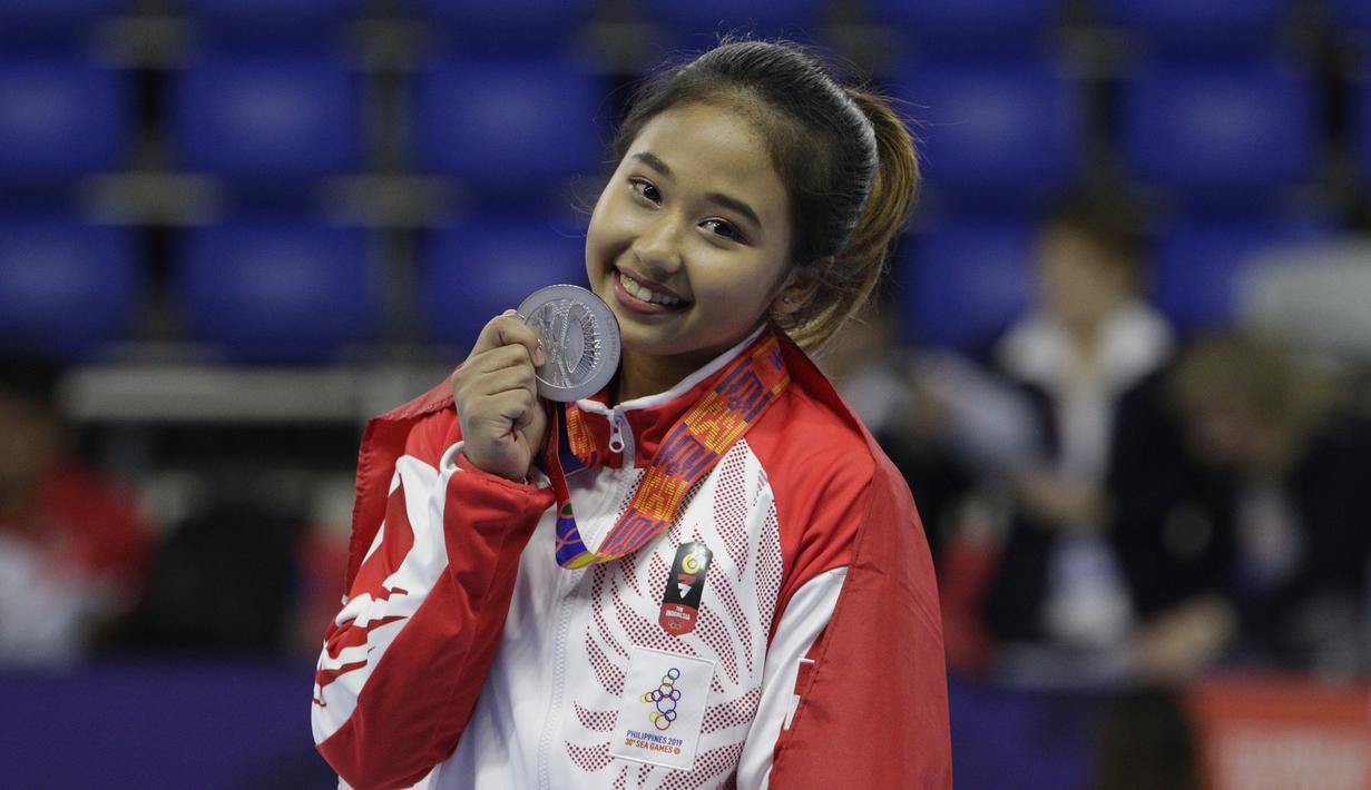 Pesenam Indonesia, Rifda Irfanaluthfi, berpose dengan medali perak usai bertanding pada SEA Games 2019 di Kompleks Rizal Memorial, Manila, Senin (2/12). Dirinya berhasil meraih medali dari nomor all-round individual putri cabang senam. (Bola.com/M Iqbal I