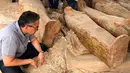 Menteri Purbakala Mesir Khaled el-Anany melihat penemuan 20 peti mati kuno di kota Luxor, 15 Oktober 2019. Peti mati ini terkubur dalam keadaan ditumpuk menjadi dua tingkatan, di mana ukiran asli wajah tangan pada peti masih terlihat jelas. (Egyptian Ministry of Antiquities via AP)