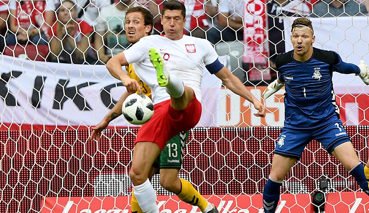 Pemain Polandia, Robert Lewandowski (kiri) berusaha melewati adangan pemain Lituania, Simonas Paulius pada laga uji coba di Stadion Narodowy, Warsaw, Polandia, (12/6/2018). Polandia menang 4-0. (AFP/Janek Skarzynski)