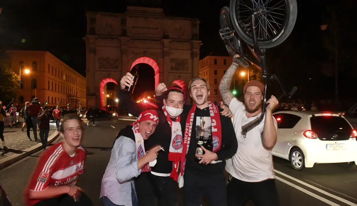 Pendukung Bayern Munchen merayakan kemenangan timnya meraih gelar juara Liga Champions setelah mengalahkan PSG pada final dimainkan di stadion Luz di Lisbon, Portugal di Munich, Jerman ,Minggu, (23/8/2020). Munchen menang 1-0 atas PSG.  (Felix H'rhager / DPA via AP)