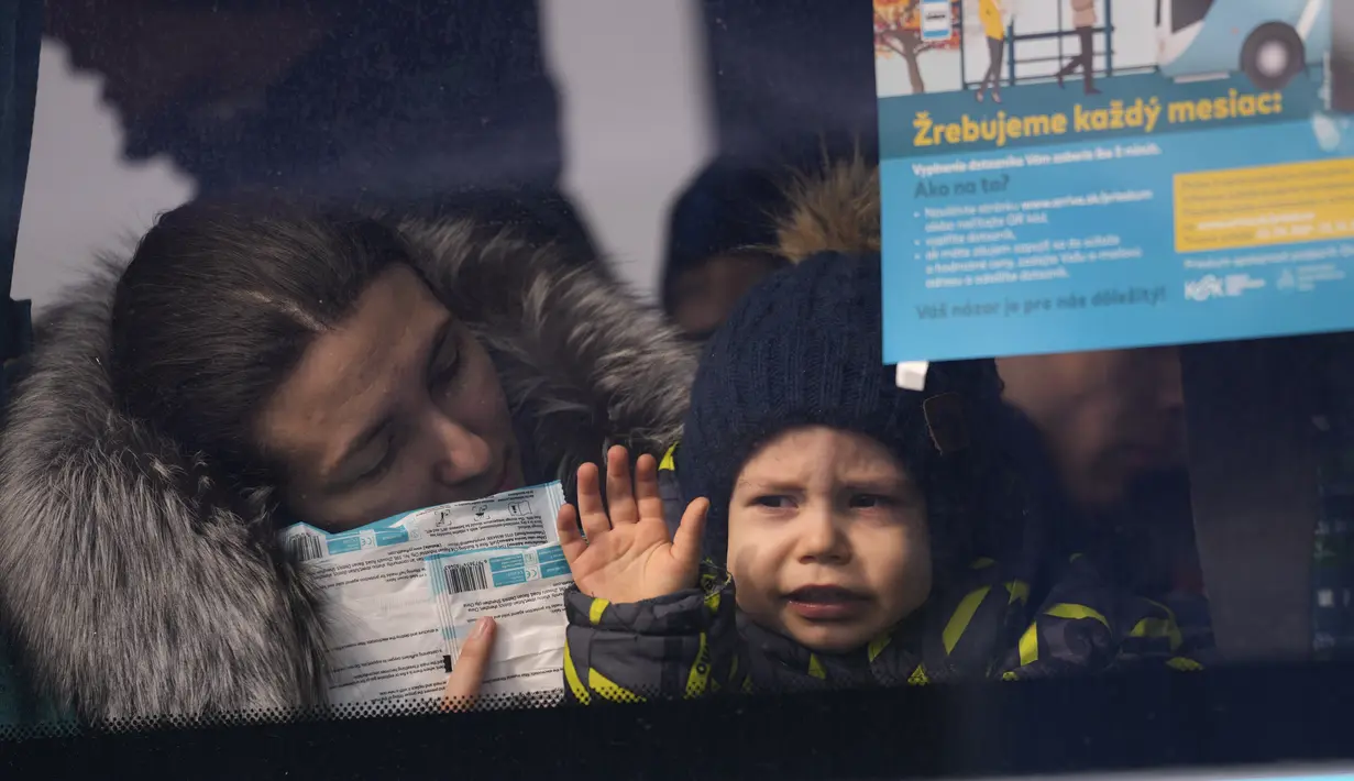 Seorang anak yang melarikan diri dari Ukraina melihat keluar dari jendela bus usai melintasi perbatasan di Vysne Nemecke, Slovakia, 3 Maret 2022. Badan pengungsi PBB, UNHCR pada Kamis (3/3) melaporkan 1 juta orang telah meninggalkan Ukraina sejak invasi Rusia sepekan lalu. (AP Photo Darko Vojinovic)