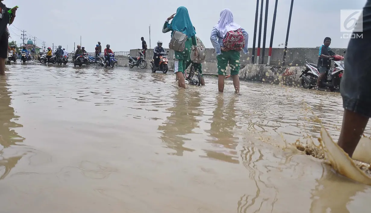 Kendaraan melintasi banjir akibat Tanggul Sungai Banjir Kanal Timur yang jebol, Semarang, Jawa Tengah, Sabtu (8/12). Akibat banjir tersebut Warga pun menyelamatkan diri tanpa sempat membawa barang pribadi miliknya. (Liputan6.com/Gholib)
