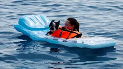 Seorang wanita dan anjingnya saat menikmati pantai anjing dan bar di Crikvenica, Kroasia, (12/7). Pantai dan bar ini dirancang khusus untuk para anjing dan pemiliknya demi merasakan kenikmatan Summertime bersama-sama. (REUTERS/Antonio Bronic)