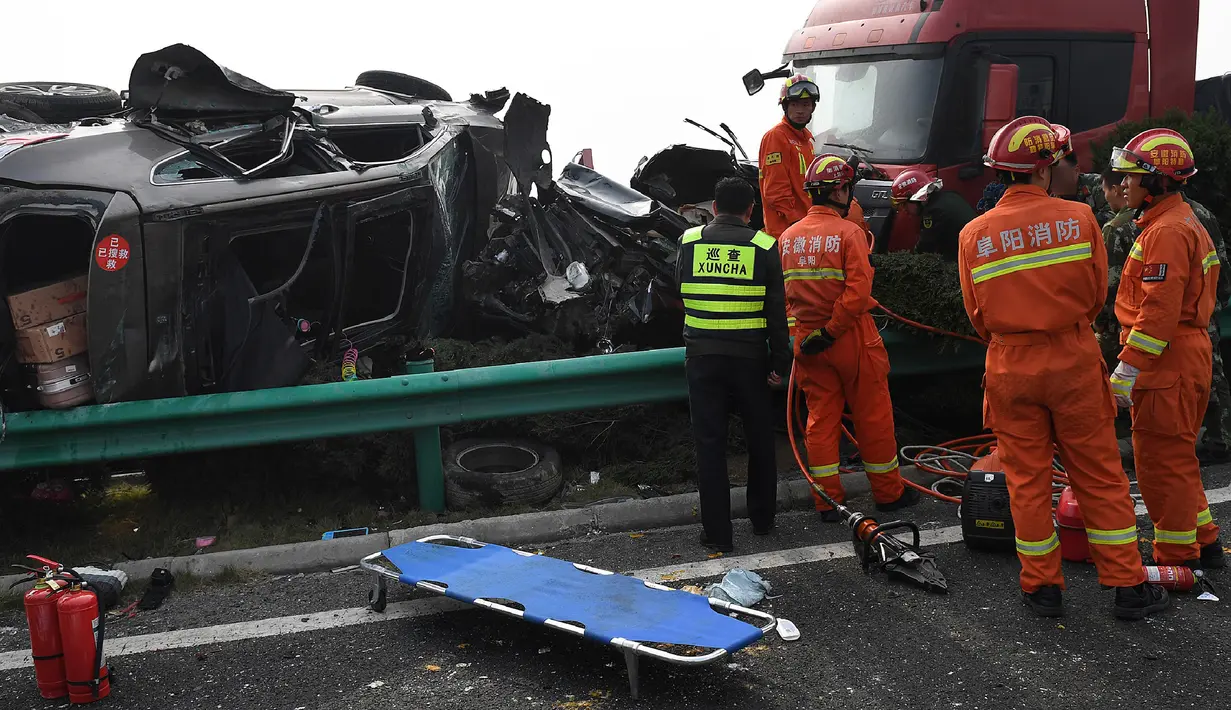 Petugas pemadam kebakaran dikerahkan ke lokasi kecelakaan beruntun 30 kendaraan di jalan raya dekat Yingshang, China timur, Rabu (15/11). Kecelakaan menyebakan api yang berkobar selama lebih dari 2 jam hingga sebagian kendaraan hancur total. (STR / AFP)