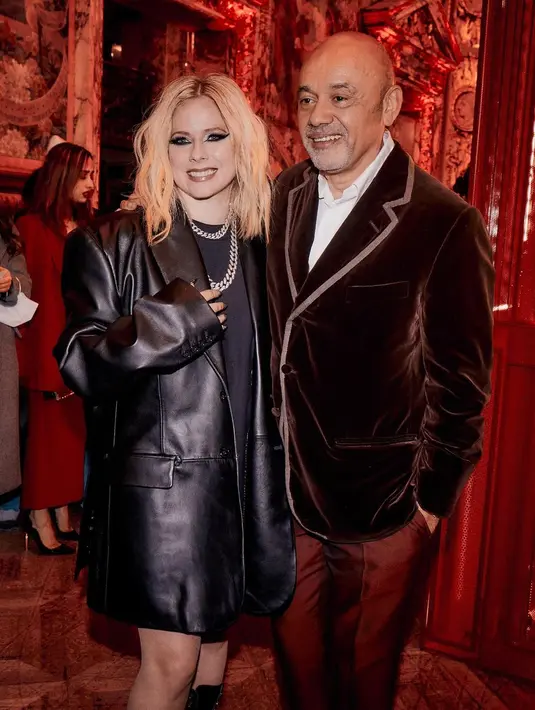 Mengenakan oversized shirt, leather long blazer, dan high lace boots [@avrillavigne]