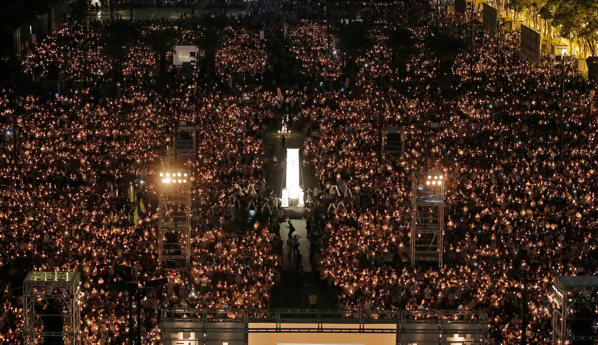 Puluhan ribu orang berkumpul sambil menyalakan lilin untuk memperingati Insiden Tiananmen di Taman Victoria Hong Kong (4/6). (AP/Vincent Yu)