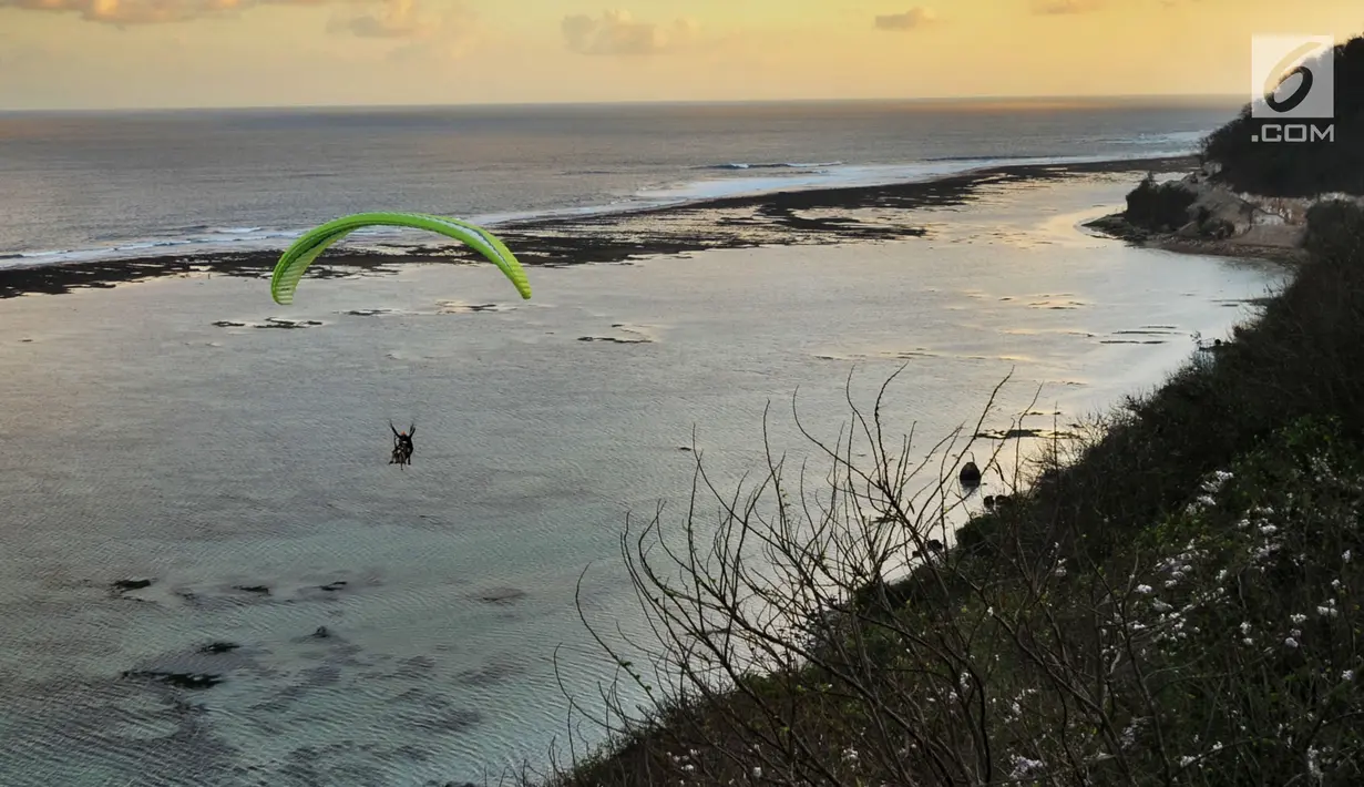 Wisatawan melakukan tandem paralayang yang difasilitasi operator Riug Paragliding di Bukit Riug, Nusa Dua, Bali (30/6). Setiap wisatawan dikenai tarif 110 dollar/ orang untuk penerbangan selama 15 menit. (Merdeka.com/Arie Basuki)