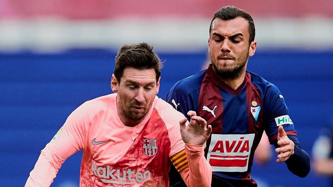 Penyerang Barcelona, Lionel Messi, saat berdue duel memperebutkan bola dengan gelandang Eibar, Joan Jordan, pada laga pekan ke-38 La Liga di Ipurua Municipal Stadium, Minggu (19/5/2019). (AP Photo/Ion Alcoba)