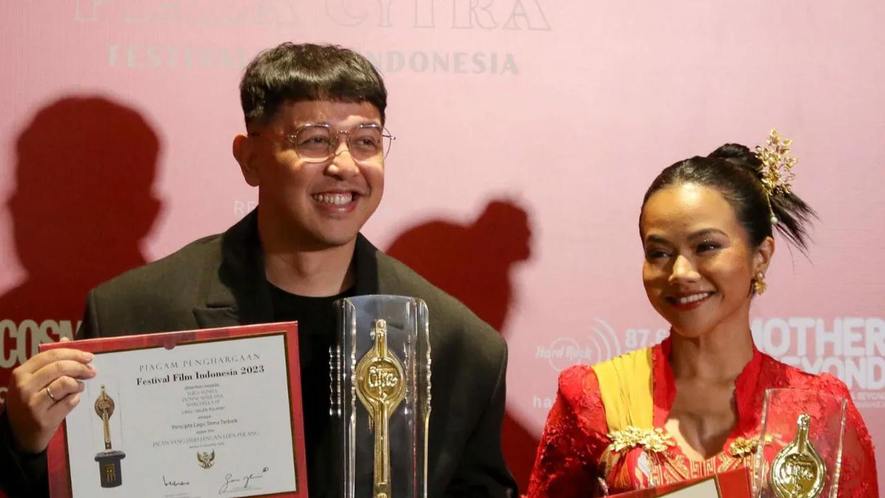 Penyanyi Yura Yunita (kanan) bersama Donne Maulana  berpose memegang piala saat menerima Anugerah Festival Film Indonesia (FFI) 2023 kategori Pencipta Lagu Tema Terbaik  di Ciputra Artpreneur, Jakarta, Selasa (14/11/2023).