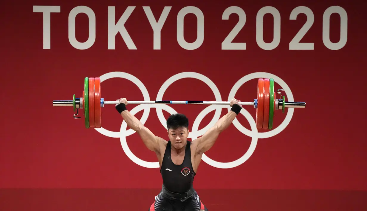 Lifter Indonesia Rahmat Erwin Abdullah saat berlaga dalam cabang olahraga angkat besi 73 kg putra pada Olimpiade Tokyo 2020 di Tokyo, Jepang, Rabu (28/7/2021). Rahmat Erwin meraih perunggu setelah memiliki total angkatan 342 kg. (AP Photo/Luca Bruno)