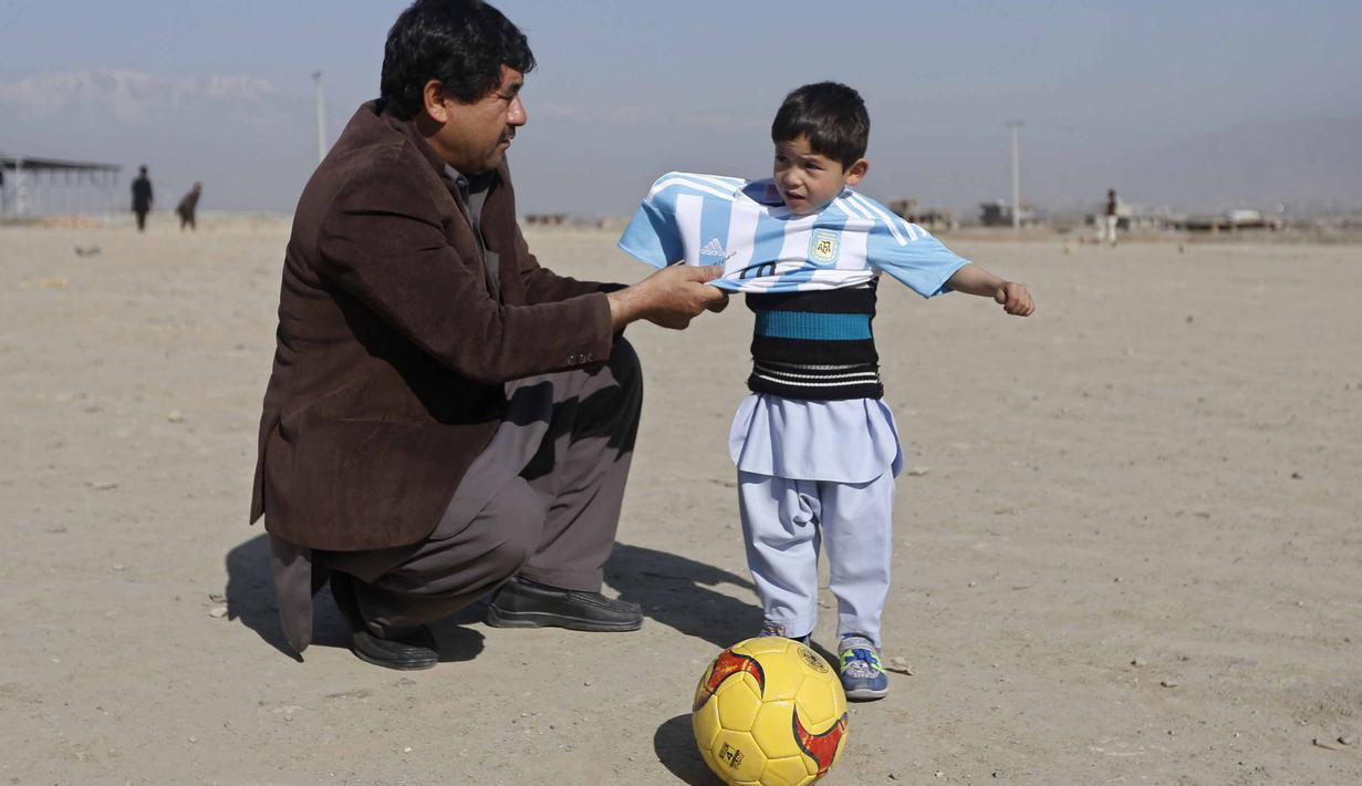 Bocah 5 tahun, Murtaza Ahmadi, asal Afghanistan menerima jersey  asli Lionel Messi lengkap dengan tanda tangan, sebelumnya bocah ini mengenakan jersey plastik nomor 10 dengan tulisan Lionel Messi. (REUTERS/Omar Sobhani)
