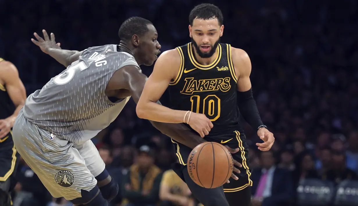 Pebasket LA Lakers, Tyler Ennis, berusaha melewati pebasket Minnesota Timberwolves, Gorgui Dieng, pada laga NBA di di Staples Center, Sabtu (7/4/2018). Timberwolves menang 113-96 atas LA Lakers. (AP/Reed Saxon)