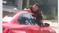 Aksi Nekat Pria 'Nemplok' di Atas Kap Mobil Merah di Jakbar Viral, Polisi Turun Tangan
