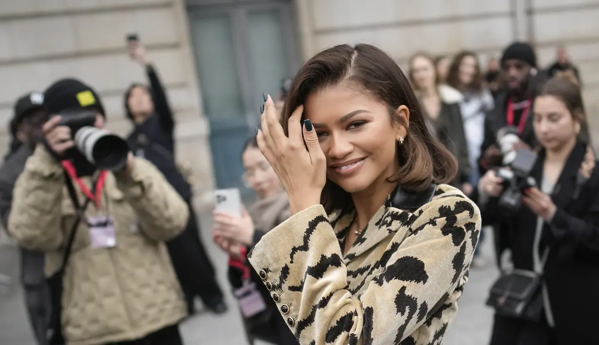 Zendaya merapikan rambutnya setelah menghadiri koleksi ready-to-wear Louis Vuitton Fall/Winter 2023-2024 selama acara Paris Fashion Week di Prancis, Senin (6/3/2023). Zendaya melengkapi tampilan memukau dengan sepatu bot setinggi lutut yang serasi dan blazer chic dengan kancing pernyataan dan kerah kulit.(AP Photo/Christophe Ena)