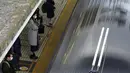 Penumpang mengenakan masker untuk mencegah penyebaran virus corona menunggu kereta di stasiun di Tokyo (8/2/2021).  Jumlah infeksi virus corona di Ibu Kota Tokyo, Jepang, meningkat sampai sembilan kali lipat sejak akhir musim panas lalu. (AP Photo/Eugene Hoshiko)