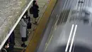 Penumpang mengenakan masker untuk mencegah penyebaran virus corona menunggu kereta di stasiun di Tokyo (8/2/2021).  Jumlah infeksi virus corona di Ibu Kota Tokyo, Jepang, meningkat sampai sembilan kali lipat sejak akhir musim panas lalu. (AP Photo/Eugene Hoshiko)