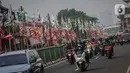 Pengendara melintas di dekat bendera parpol yang terpasang di pembatas jalan kawasan Tebet, Jakarta, Selasa (25/7/2023). (Liputan6.com/Faizal Fanani)