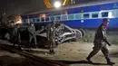 Petugas keamanan setempat saat membantu mengevakuasi korban kecelakaan kereta api yang terjadi di Pukhrayan, Kanpur, India (21/11). Diduga masih banyak korban yang terperangkap di dalam bangkai kereta api. (Reuters/ Jitendra Prakash)