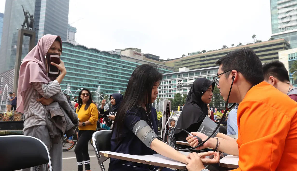 Warga mengecek darah saat car free day (CFD) di Jakarta,Minggu (13/1). Pengecekan darah yang dilakukan oleh para mahasiswa di Jakarta ini agar masyarakat dapat menjaga pola hidup sehat. (Liputan6.com/Angga Yuniar)