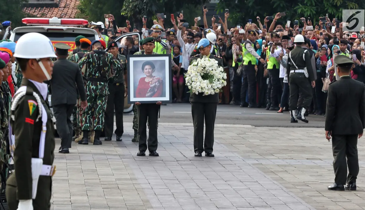 Prajurit TNI menurunkan peti jenazah istri presiden ke-6 RI Susilo Bambang Yudhoyono (SBY), Ani Yudhoyono dari ambulans di TMP Kalibata, Jakarta, Minggu (2/6/2019). Ani Yudhoyono dimakamkan di samping pusara istri presiden ke-3 RI BJ Habibie, Ainun Habibie. (Liputan6.com/JohanTallo)