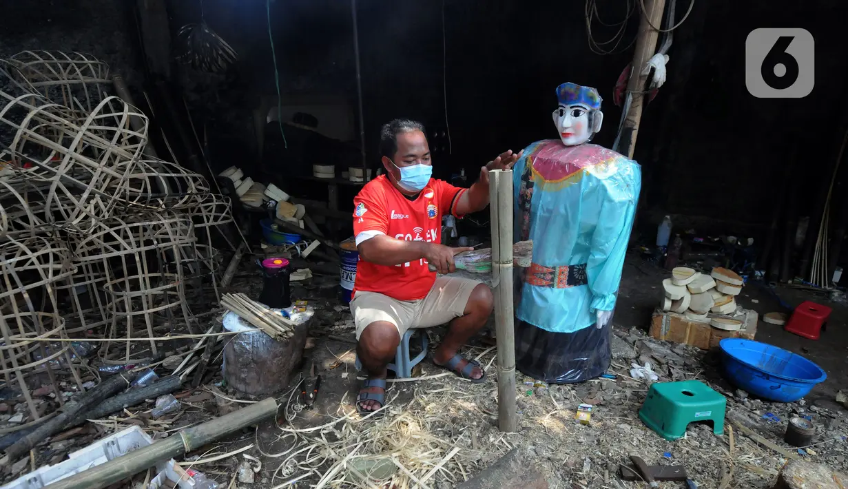 Pekerja membuat ondel-ondel di Rumah Produksi Ondel-Ondel Jakarta, Setu Babakan, Jakarta Selatan, Minggu (19/9/2021). Ondel-ondel dijual dengan harga Rp 35 ribu hingga Rp 7 juta per pasang. (merdeka.com/Arie Basuki)