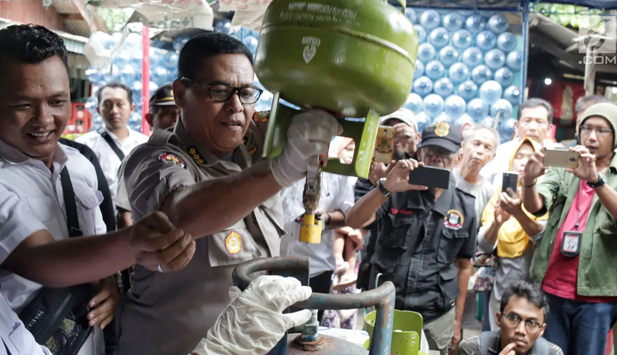 Kabid Humas Polda Metro Jaya Kombes Pol Argo Yuwono menunjukkan proses penyuntikan tabung gas di Cipayung, Jakarta, Selasa (22/1). Subdit III Sumdaling Ditreskrimsus Polda Metro Jaya membekuk empat tersangka dalam kasus ini. (Liputan6.com/Faizal Fanani)