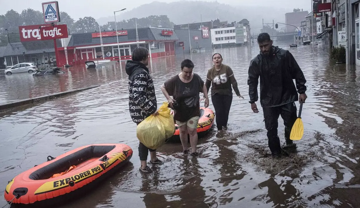 Warga menggunakan rakit karet untuk mengungsi setelah Sungai Meuse jebol saat banjir besar di Liege, Belgia, Kamis (15/7/2021). Hujan lebat dan banjir telah menewaskan sedikitnya 59 orang di Jerman dan sembilan di Belgia. (AP Photo/Valentin Bianchi)