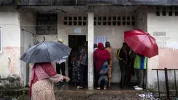 Para pemilih mencari nama mereka di daftar pemilih di sebuah tempat pemungutan suara di Moroni, Komoro pada 14 Januari 2024. (OLYMPIA DE MAISMONT/AFP)