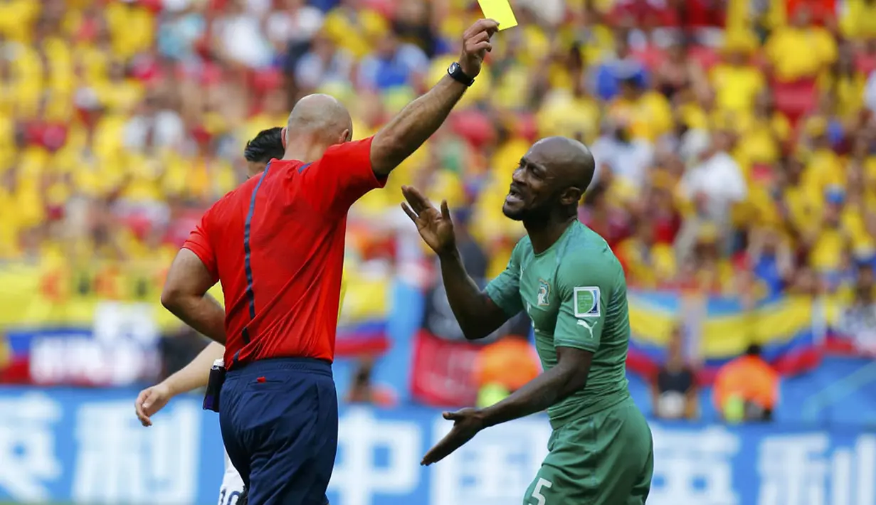 Dua kartu kuning dikeluarkan wasit Howard Webb (Inggris - kiri) di Stadion National Mane Garrincha, Brasil, (19/6/2014), salah satunya diberikan untuk pemain belakang Pantai Gading, Didier Zokora. (REUTERS/Paul Hanna)
