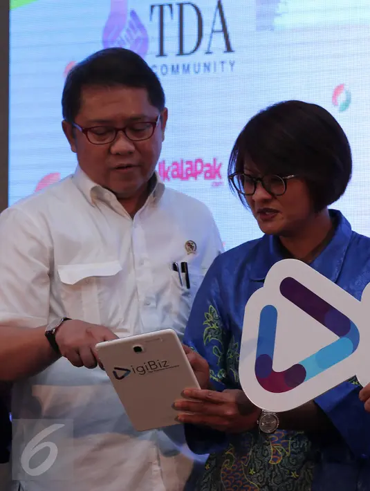 Ceo PT XL Axiata Dian Siswarini (kanan) menjelaskan tentang aplikasi DigiBiz kepada Menkominfo Rudiantara saat peluncuran Aplikasi Digibiz di Jakarta, Selasa (02/12). (Liputan6.com/Angga Yuniar)
