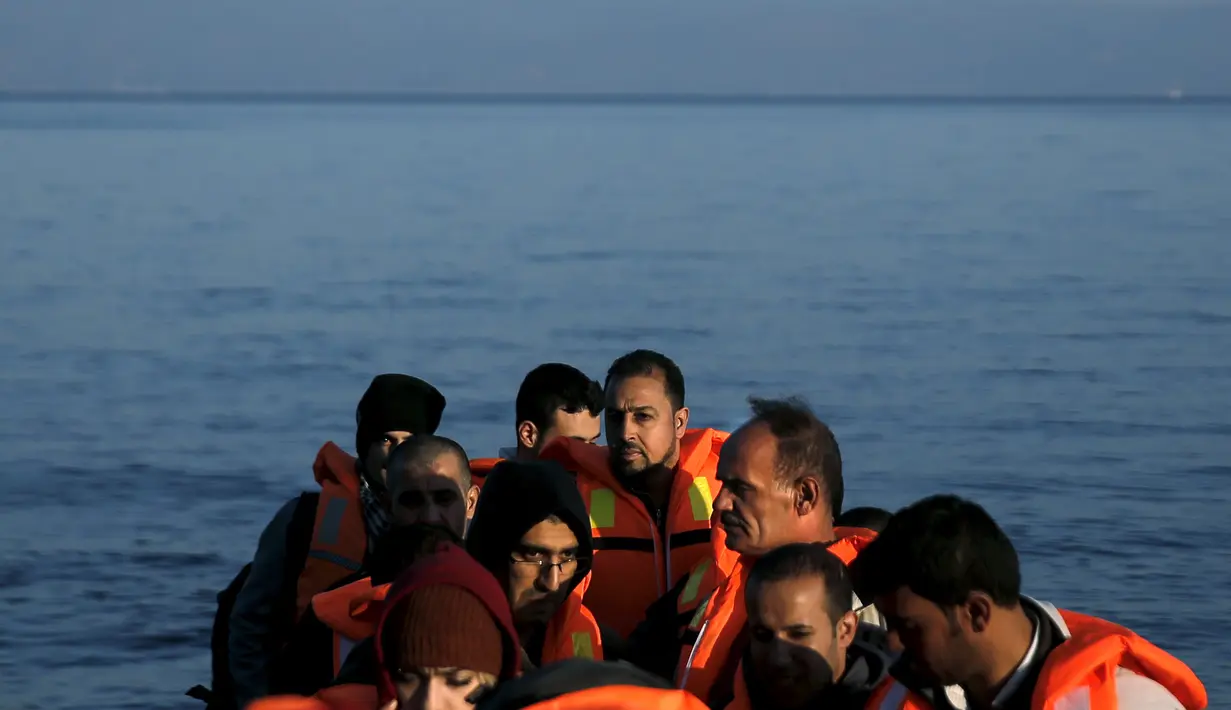 Pengungsi dan imigran saat berada di kapal di sampan kecil usai melintasi pulau Lesbos, Yunani, Senin (9/11). Sejak tahun 2015 lebih dari 590.000 imigran menyeberang ke Yunani akibat perang yang terjadi di Suriah. (REUTERS/Alkis Konstantinidis)