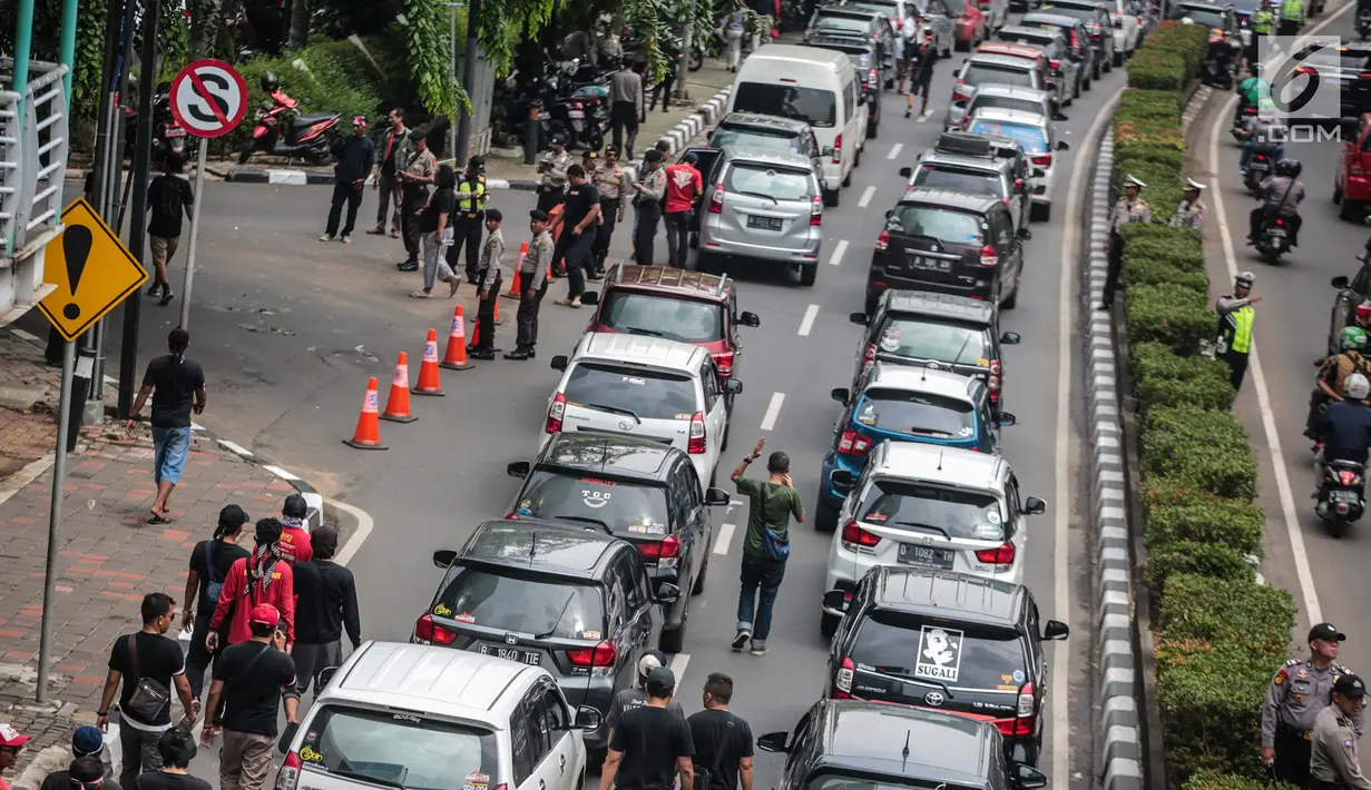 Sejumlah mobil pengemudi online menutup jalur lambat saat mereka menggelar demo di kantor pusat Grab kawasan Kuningan, Jakarta, Senin (29/10). Akibat aksi tersebut, kemacaten parah terjadi dari arah Mampang menuju Menteng. (Liputan6.com/Faizal Fanani)