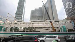Pekerja menyelesaikan proyek revitalisasi Halte TransJakarta Bundaran Hotel Indonesia di Jakarta, Kamis (15/4/2022). Sembilan halte TransJakarta akan difungsikan kembali secara bertahap sampai dengan diselesaikan secara keseluruhan pada Desember 2022. (Liputan6.com/Faizal Fanani)