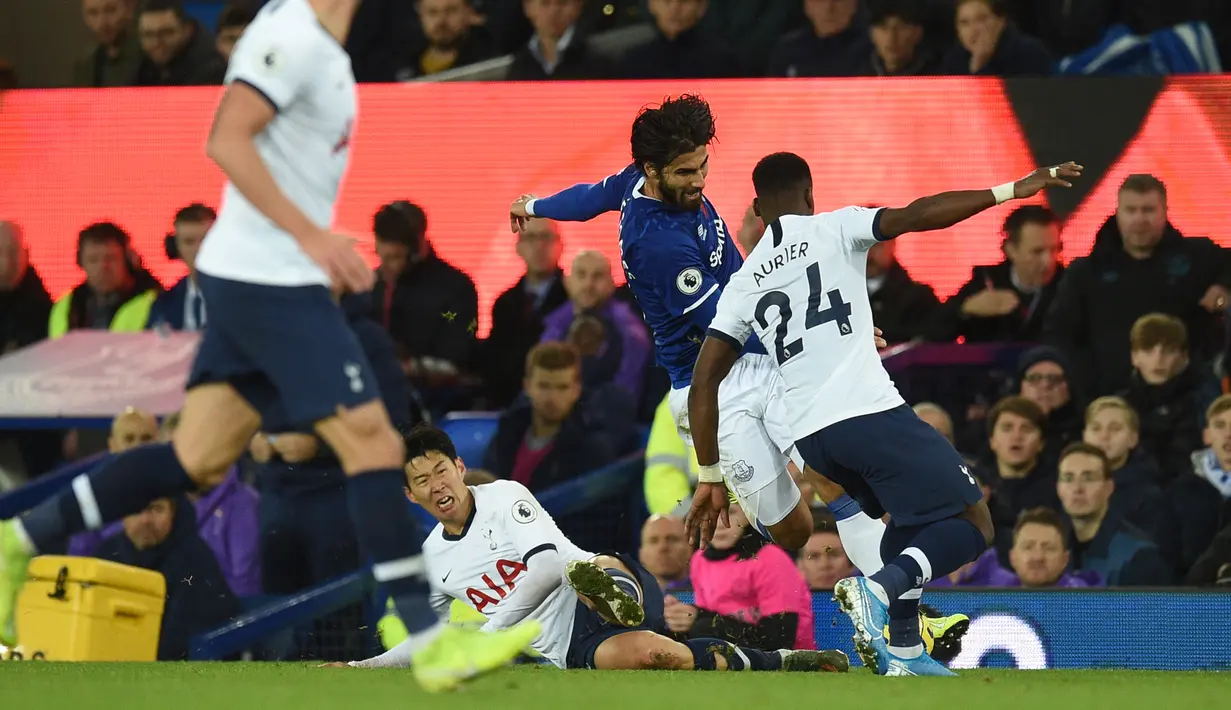 Gelandang Everton Andre Gomes (tengah) ditekel striker Tottenham Hotspur Son Heung-min pada pertandingan Liga Inggris di Goodison Park, Liverpool, Inggris, Minggu (3/11/2019). Tekel Son Heung-min menyebabkan Andre Gomes patah kaki. (Oli SCARFF/AFP)